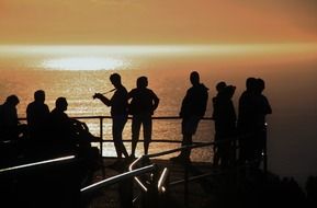 dark silhouettes of people on the coast of africa in yellow twilight