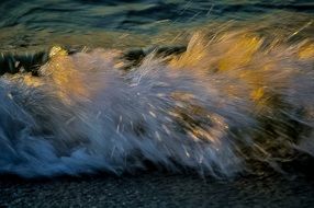 waves in the yellow rays of the sun in a blurred background