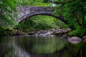 stone bridge over the pond in the forest coed y brenin