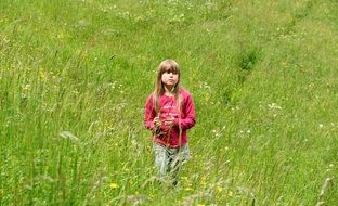 child in a pink green field