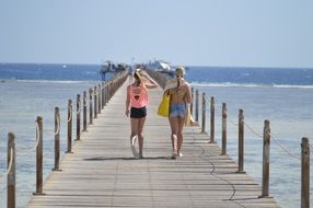 girls walking away wooden pier sea landscape