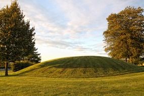 summer landscape with trees besides of burial mound
