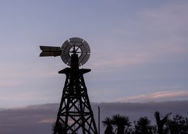 windmill outlines western texas evening sky