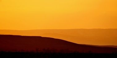 Picturesque landscape with silhouettes of mountains at sunset