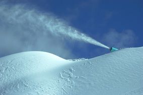 snow cannon on hill at sky