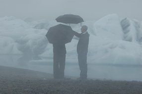 People under umbrellas near the Glacial Lake