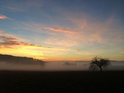 haze over the fields at sunset