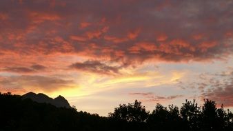 silhouettes of mountains against the sky at sunrise