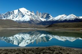 snow-capped mountains are reflected in the water in patagonia