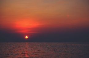 orange sun and pink sunset over the sea
