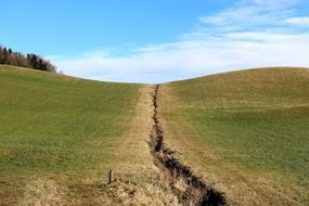 pothole on a green hill