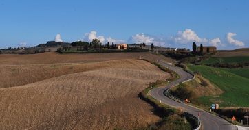 road amidst a picturesque landscape in tuscany