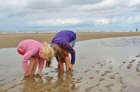 two kids on the sand beach on the north sea coast