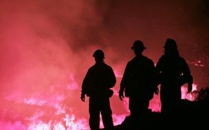 dark silhouettes of firefighters on fire