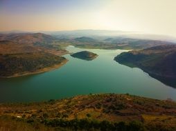 a lake with turquoise water between the hills