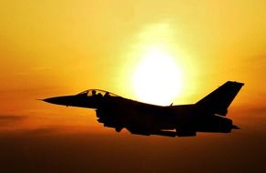 silhouette of a military aircraft at sunset