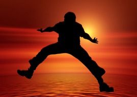 silhouette of male person jumping at sunset sky