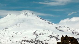 the top of the mountain in the snow on the background of the cloudy sky