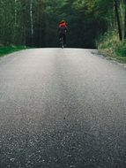 the boy rides on the asphalt on a bicycle