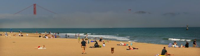 People on the beach against the backdrop of the Golden Gate Bridge
