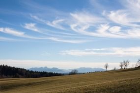 cirrus clouds above field and distant mountains, rural landscape, germany, bavaria