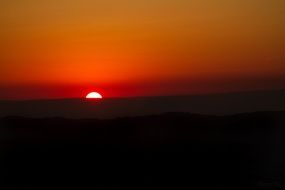 distant view of the red sun at sunset