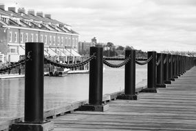 pier jetty chain along river black and white photo