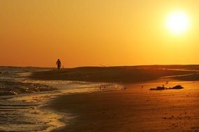 lonely man on the beach at sunset