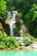 beautiful waterfall in the forest under the rays of the sun