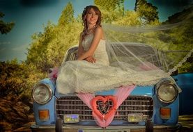 bride on the hood of a vintage car