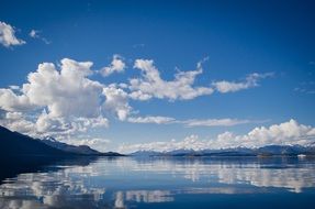 scenic clouds mirroring on blue water at coastline