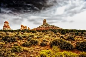 scenic buttes in desert at grey cloudy sky, usa, utah, arizona