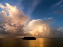 island in the ocean under the clouds
