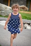 running little girl in polka dot dress