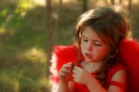 little girl in a red costume of a angel