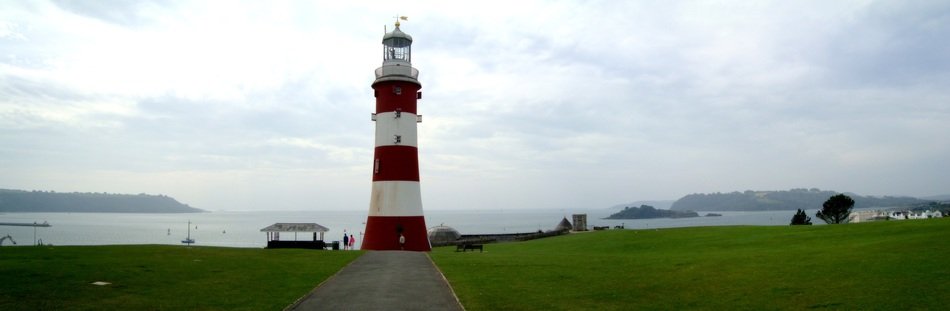 red and white lighthouse stands near the sea