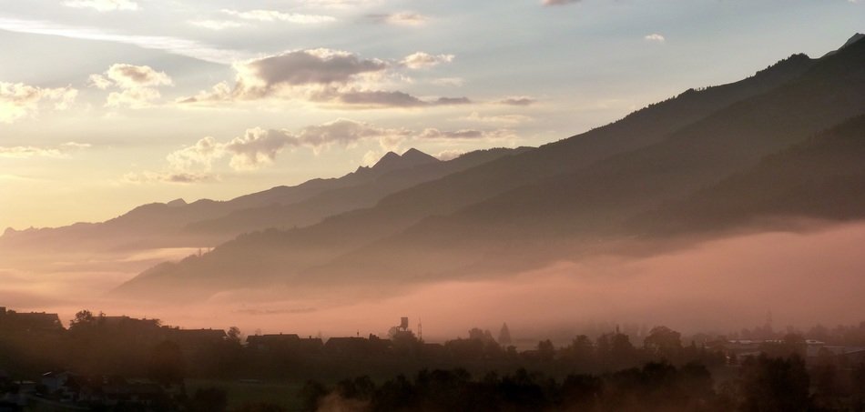 morning fog over the village at the foot of the mountain