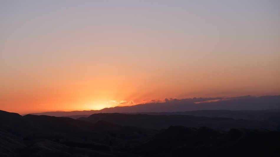 The setting sun behind the hills
