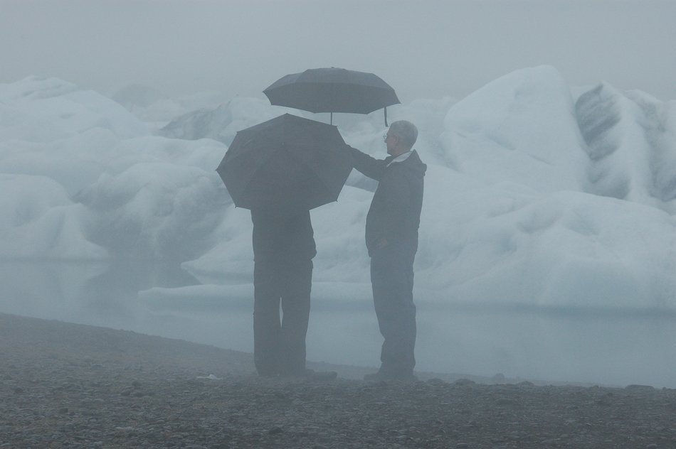 People under umbrellas near the Glacial Lake