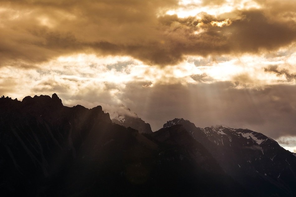 Sunlight through the clouds above the mountain peaks