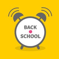Alarm clock with chalk text yellow background Back to school