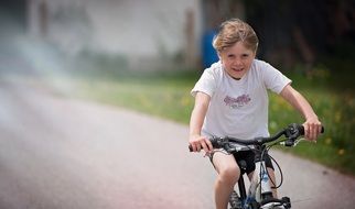 The little girl is riding a bicycle