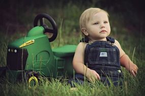 kid near big toy on green grass