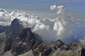 white clouds above the sharp peaks of the alps