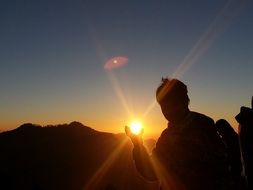 photo where a man holds the sun
