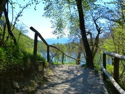 walk path with wooden railing to tenno lake, italy