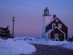 harbor lighthouse in winter against a purple sky