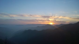 orange sun rises over the mountains