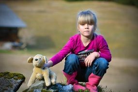 Blonde girl with stuffed animal country view