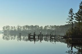 idyllic landscape with forest at river and pier